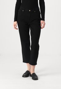 Zwarte geblokte broek van een katoenmix met een gladde textuur, voorzien van een knoopsluiting en twee zijzakken. Gecombineerd met zwarte instappers.