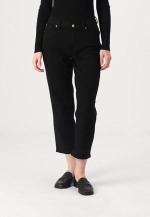 Black cropped pants made of cotton blend with a smooth texture, featuring a button closure and two front pockets. Paired with black loafers.