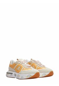 Paire de baskets basses orange et beige avec semelles intermédiaires graphiques blanches et jaunes et lacets rose clair sur fond blanc.