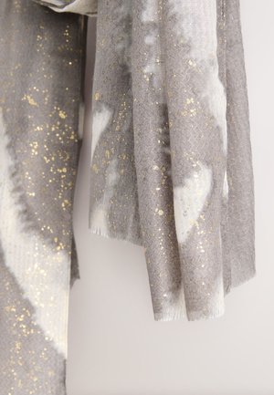 Sciarpa grigia e bianca con una texture morbida a motivo spina di pesce, arricchita da pagliuzze dorate e bordi sfrangiati.