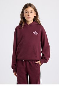 Tummanpunainen huppari, jossa etutasku, kiristysnauhalla varustettu huppu ja vaaleanpunainen "The Morning Club" -logo. Pehmeästä kankaasta valmistettu, rento istuvuus.