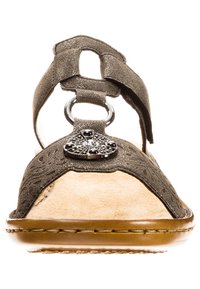 Brown leather sandals with a textured upper, featuring a decorative metallic accent and a cushioned footbed. Open-toe design.