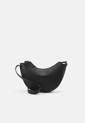 Zwarte leren crossbodytas in de vorm van een halve maan met ritssluiting en verstelbare riem op een effen lichte achtergrond.