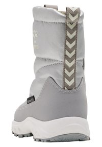 Grå vattentät vinterstövel med övre del av mjukt tyg, gummisula och mönstrad dragflik. Har en logotyp på baksidan och texturerade detaljer.