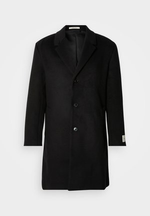 Palton negru din lână cu închidere cu un singur nasture, rever cu zimți, mâneci lungi și o siluetă curată. Include un accent la manșetă etichetat.