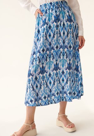 Jupe maxi à motif bleu avec une taille élastique, présentant un design de style aquarelle dans diverses nuances de bleu et de blanc.