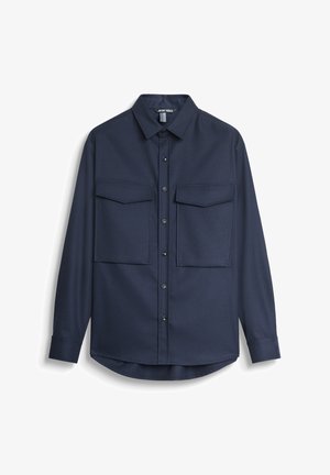 Camisa de botón de color azul marino hecha de una tela con textura suave, que presenta dos bolsillos frontales y un diseño de cuello clásico.