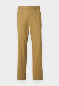 Pantalon en coton beige à coupe droite, avec poches avant et fermeture à bouton. Texture lisse et design minimal, sans motifs visibles.