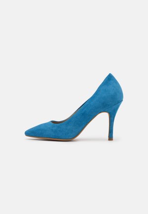 Modré semišové lodičky na vysokém podpatku s špičatou špičkou, elegantní silueta a přibližně 10 cm vysoký jehlový podpatek. Hladká textura a jednotná barva.
