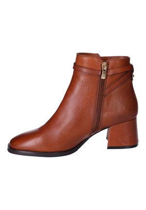 Bottine en cuir marron, fermeture éclair sur le côté, talon carré, bout pointu, texture lisse, coutures discrètes et détail de sangle autour de la cheville.