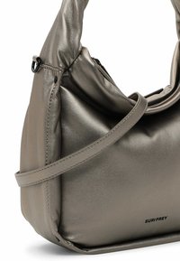 Borsa a spalla grigia metallica con texture liscia, design curvo, tracolla regolabile e logo goffrato. Presenta una tasca con zip per la chiusura.