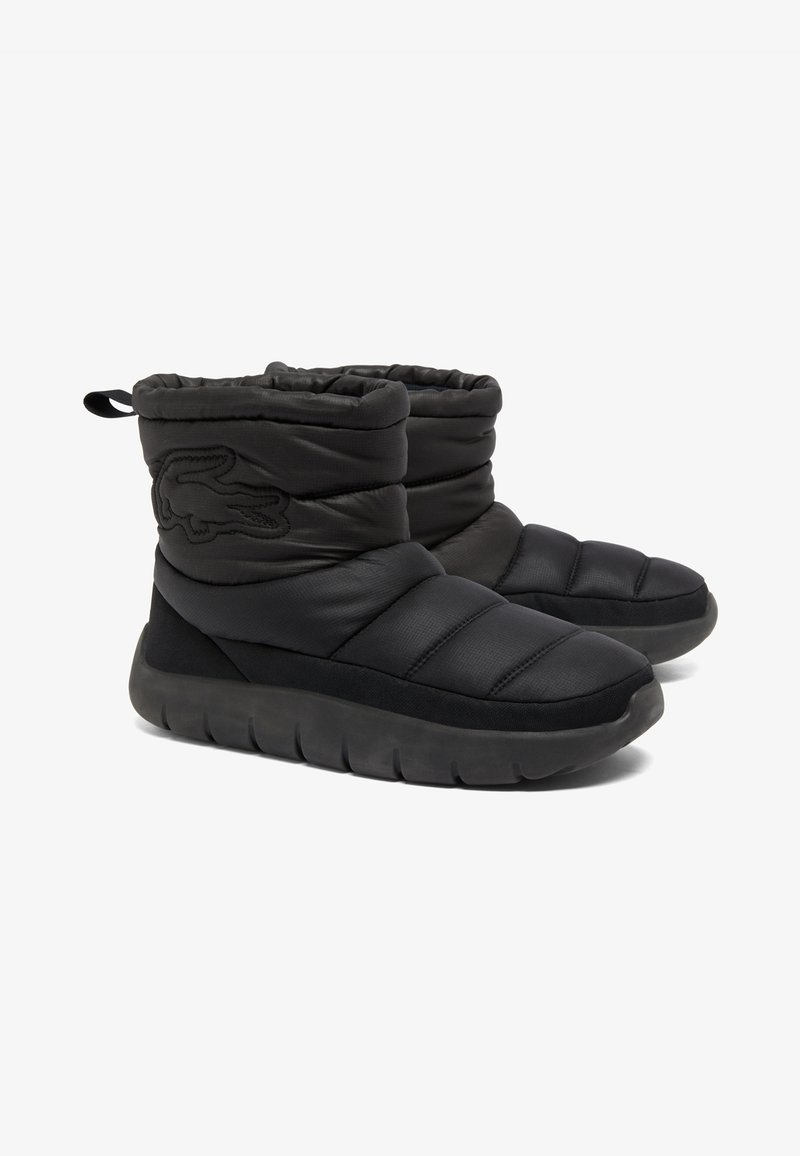 Schwarze, gepolsterte Knöchelstiefel mit einem weichen Nylon-Außenmaterial, runder Zehenpartie und strukturiertem Gummisohle. Mit einem dezenten Logo an der Seite und einem Ziehschlaufen.