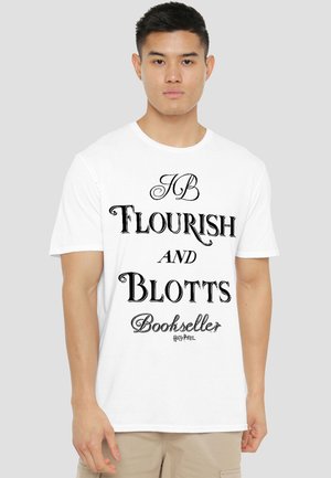 Young man wearing white t-shirt with black text reading "Flourish and Blotts Bookseller" and small "Harry Potter" logo below.