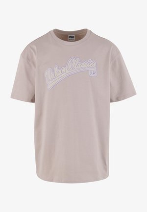 Beige cotton t-shirt with short sleeves, rounded neckline, and a white and purple "Urban Classics" logo across the chest.