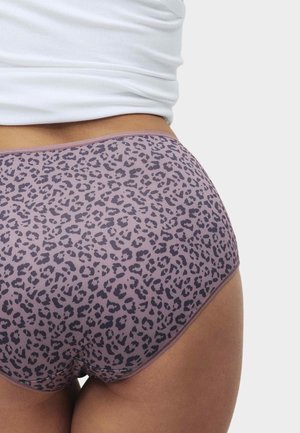 Gros plan d'une personne portant un sous-vêtement taille haute mauve avec un motif léopard foncé et un top blanc côtelé.