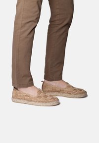 Tkané espadrilky s karovaným vzorom v béžovej a hnedej farbe, so juta podrážkou a dizajnom na obúvanie.