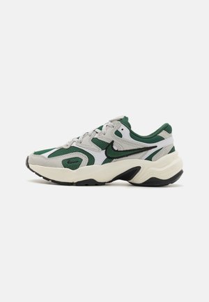 Green and gray athletic shoe with mesh and leather materials, rounded shape, white accents, and a thick black sole.