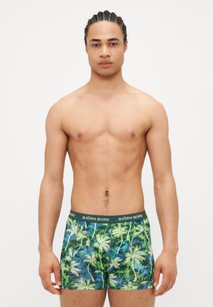 Herreboxershorts med et livlig palmebladtrykk i grønt og blått, laget av elastisk materiale med en svart merket livrem.