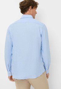 Lichtblauw langemouwen shirt van textuurstof, met knopenmanchetten en een klassieke kraag, voorzien van een rechte zoom en rugpasdetail.