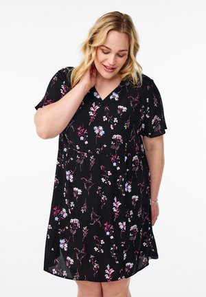 Zwarte jurk met korte mouwen en een V-hals, voorzien van een kleurrijk bloemenpatroon in roze, blauw en wit op een vloeiende stof.