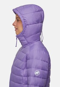 Veste isolée violette avec une capuche, au design matelassé et fermeture à cordon. Présente un logo sur le bras gauche et une texture lisse et brillante.