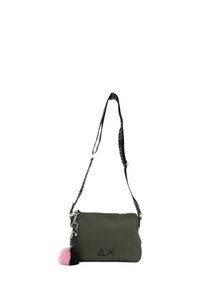 Borsa a tracolla verde oliva con logo nero, materiale testurizzato, chiusura con zip e charm a pom-pom staccabile rosa e nero. Spallaccio regolabile.