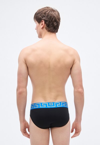 Μαύρα μαγιό σλιπ με μπλε ζώνη μέσης διακοσμημένη με μοτίβο ελληνικού κλειδιού. Λείο υφή, εφαρμοστό σχήμα για αεροδυναμική εμφάνιση.