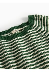 Chandail en tricot rayé avec des couleurs vertes et crème, encolure côtelée et tissu texturé avec une étiquette de marque visible.