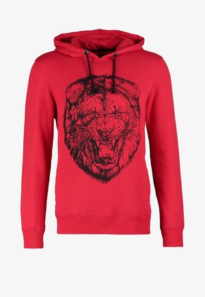 Rode hoodie met een zwarte leeuwengrafiek, geribbelde manchetten en zoom. Gecombineerd met strakke zwarte broek en bordeauxrode sneakers.