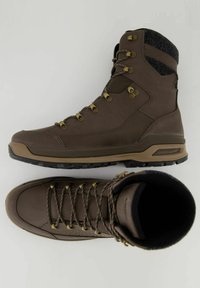 Bruine wandelschoenen hebben een robuust ontwerp, bestaan uit leer en textiel, hebben metalen veteroogjes en een gestructureerde rubberen zool voor grip.