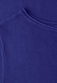 Tissu tricoté de couleur violet profond, présentant une texture lisse et un col arrondi avec des bords côtes. Il n'y a aucun motif ni accessoire visible.