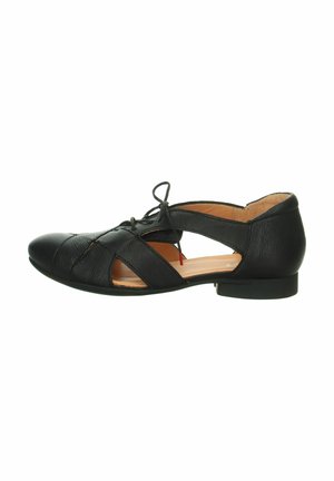 Chaussure plate en cuir noir avec bout pointu, côtés découpés et détail de lacets à l'avant.