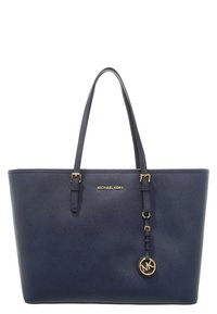 Borsa a mano in pelle sintetica blu navy con accessori in oro, due manici lunghi e un charm con logo su un cinturino. Texture liscia, forma strutturata.