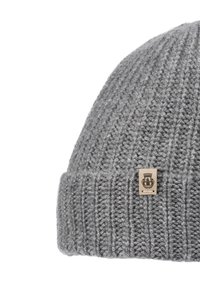 Gray knitted wool beanie with ribbed texture and a small rectangular leather patch featuring a black emblem on the folded edge.