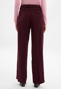 Bordeaux corduroy wijde broek met een textuur, voorzien van twee achterzakken en een hoge tailleband. Vlakke voorkant, getailleerde pasvorm.