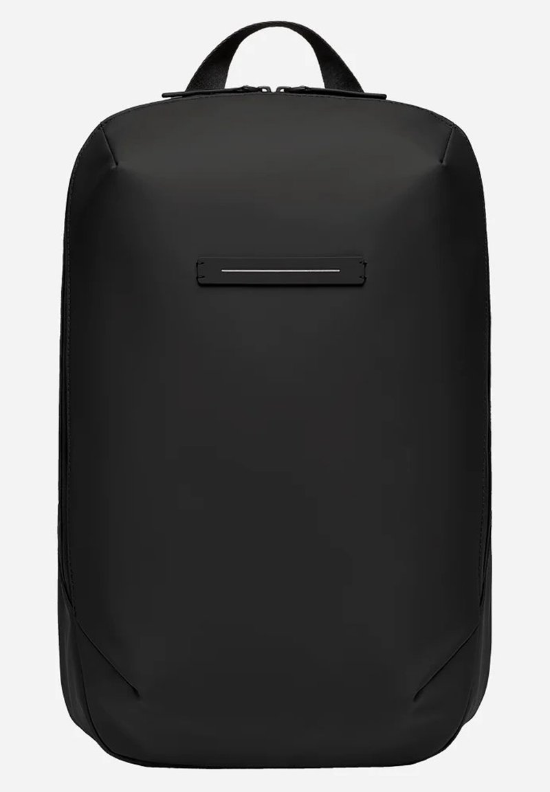 Sac à dos noir en tissu mat avec une forme rectangulaire élégante. Dispose d'une poche frontale horizontale et de bretelles ajustables.