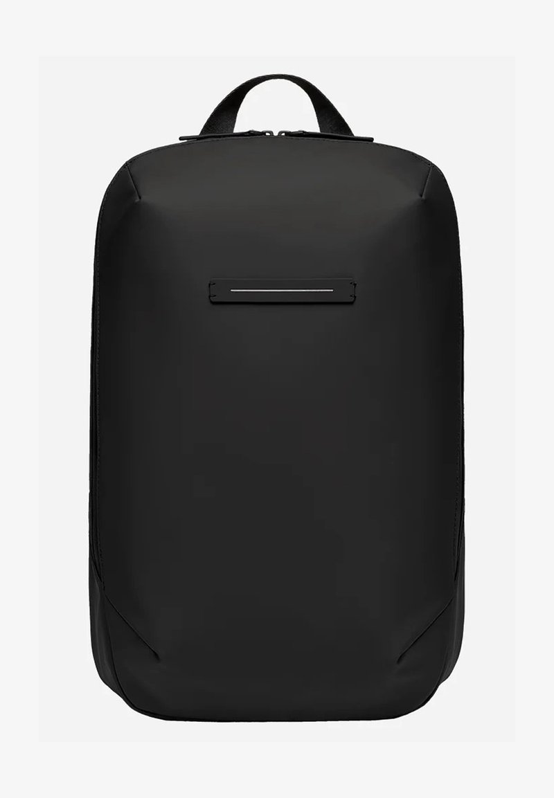 Sac à dos noir en tissu mat avec une forme rectangulaire élégante. Dispose d'une poche frontale horizontale et de bretelles ajustables.