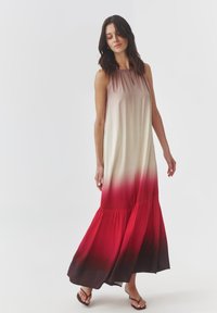 Robe maxi avec une transition de couleur dégradée du beige au rouge profond au bas. Dotée d'un col froncé et d'un bas évasé. Tissu lisse.