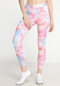 Legginsy Nike w pastelowym geometrycznym wzorze w odcieniach różu, niebieskiego i białego. Posiadają wysoki stan i dopasowany krój.