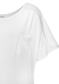 Weißes Kurzarmoberteil mit strukturierten Mesh-Akzenten an den Schultern und einer diamantartigen aufgenähten Tasche. Glattes Material, lockere Passform.