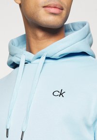 Calvin Klein Golf PLANET HOODIE - Sweatshirt com capuz - air blue