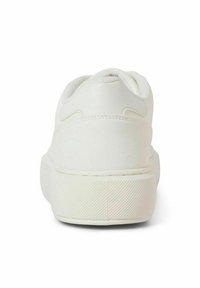 White sneaker featuring a smooth, matte fabric upper, padded collar, and textured rubber sole with a herringbone pattern.