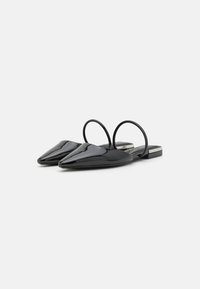 Zwarte gepatineerde leren slingback schoenen met puntige neuzen, flexibele bandjes en een kleine hak met zilveren accent. Glad, glanzend textuur.