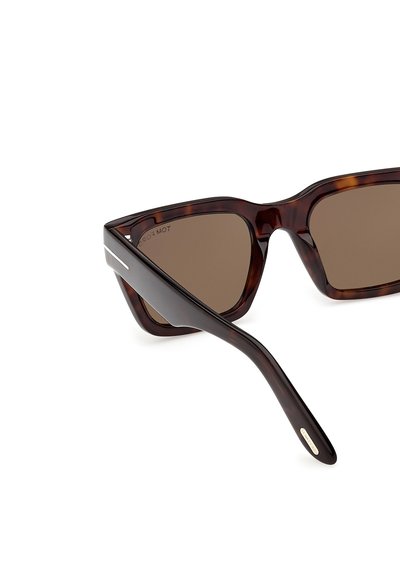 Bruine schildpadrechthoekige zonnebril met dikke monturen en donkere lenzen, schuin weergegeven op een witte achtergrond.