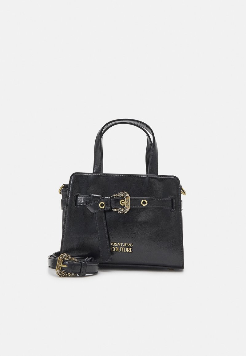 Sac à main en cuir noir avec double poignée, boucle dorée décorative et bandoulière, et logo doré "Versace Jeans Couture" à l'avant.