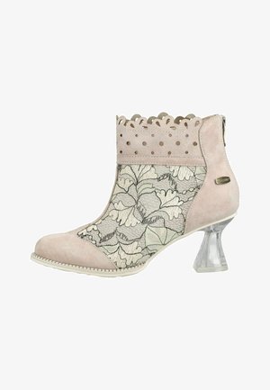 Beiger Stiefel mit Blumen-Spitzeinsatz, gezacktem und perforiertem Wildleder-Schaft und transparentem ausgestelltem Absatz.