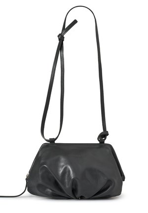 Czarna skórzana torba na ramię z marszczonym, marszczonym wzorem i regulowanym cienkim paskiem na białym tle.