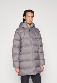 Manteau matelassé gris avec capuche, doté d'une fermeture éclair à l'avant, d'un motif matelassé et de manches longues. Le matériau semble doux et léger.