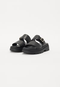 Sorte platform sandaler med flere brede stropper og en sidebuckle. Glat tekstur med perforeret fodseng og en kraftig, mønstret sål.