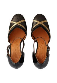 Chaussures slingback noires et dorées avec un dessus en tissu métallique, un design à brides croisées et une semelle intérieure en cuir lisse.